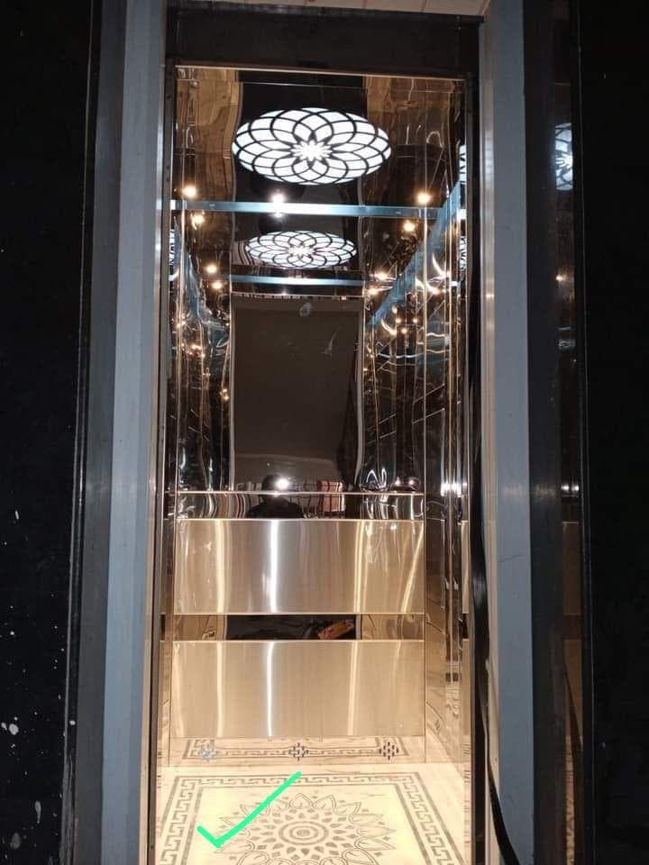 Modern mirror-finish elevator entrance with decorative ceiling