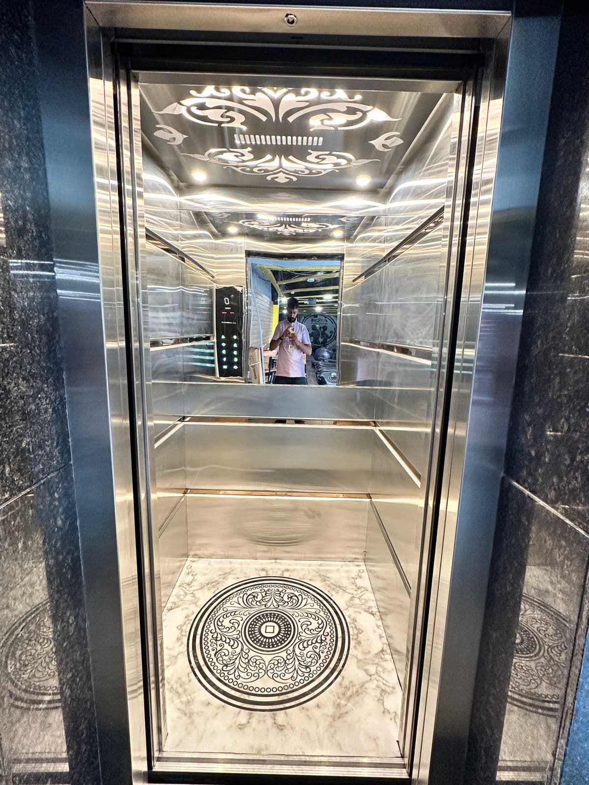 Premium elevator cabin with reflective panels and marble-style flooring